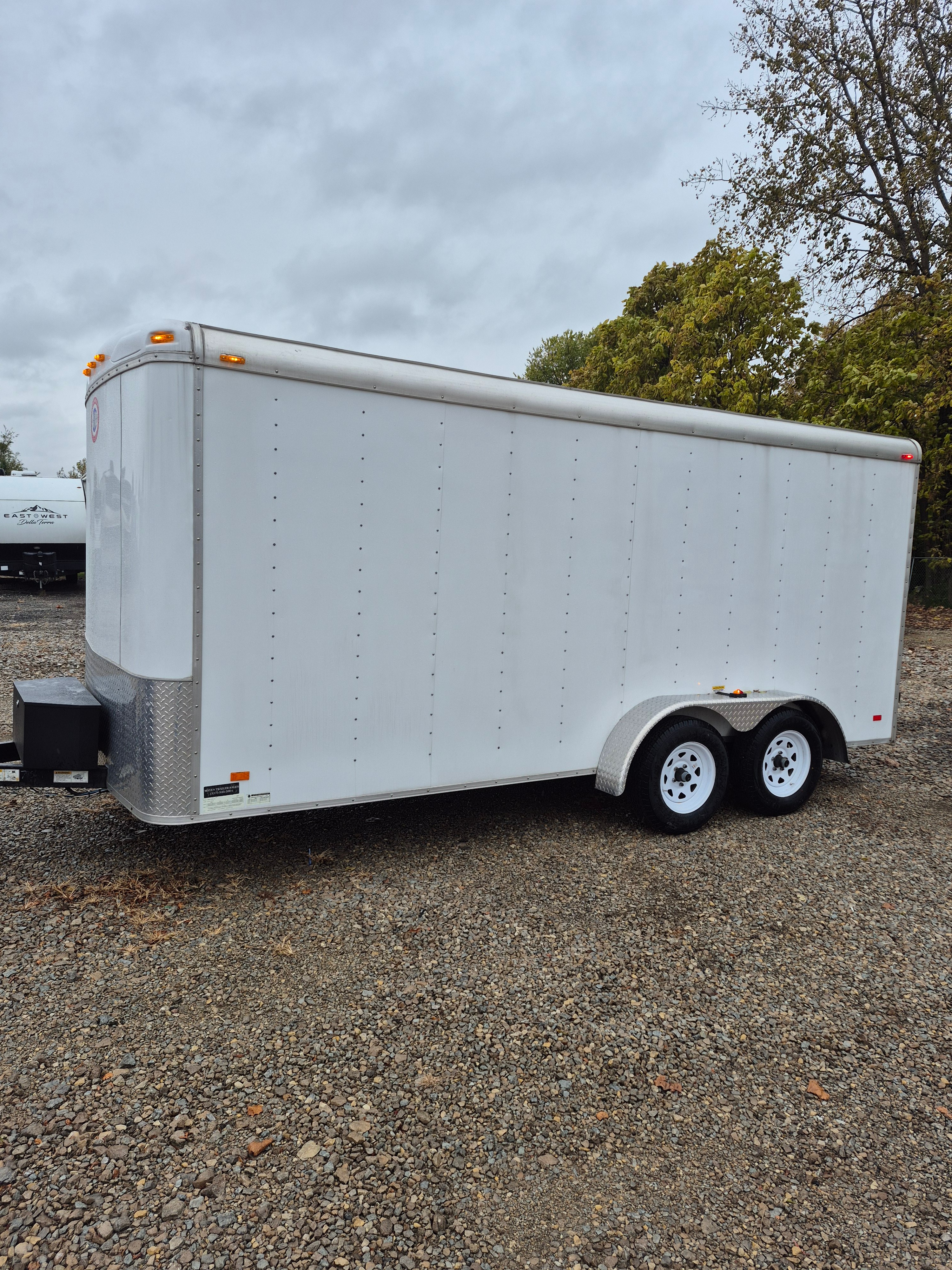 7ft x 16ft enclosed cargo trailer exterior side view - white trailer with dual axles available for rent in Greenfield, IN