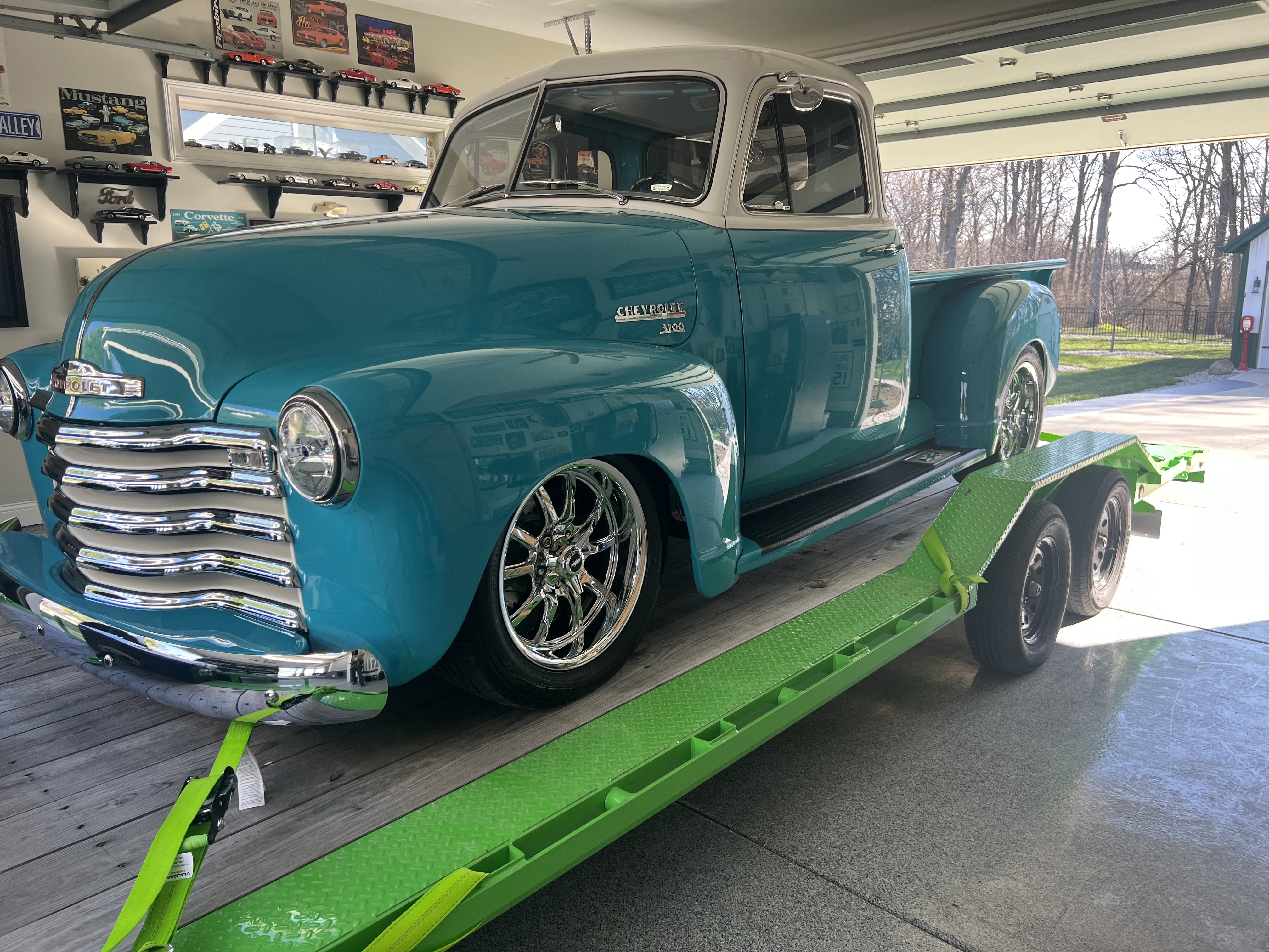 Vintage Chevrolet pickup truck secured on green flatbed trailer for classic car transport in Splendora, TX